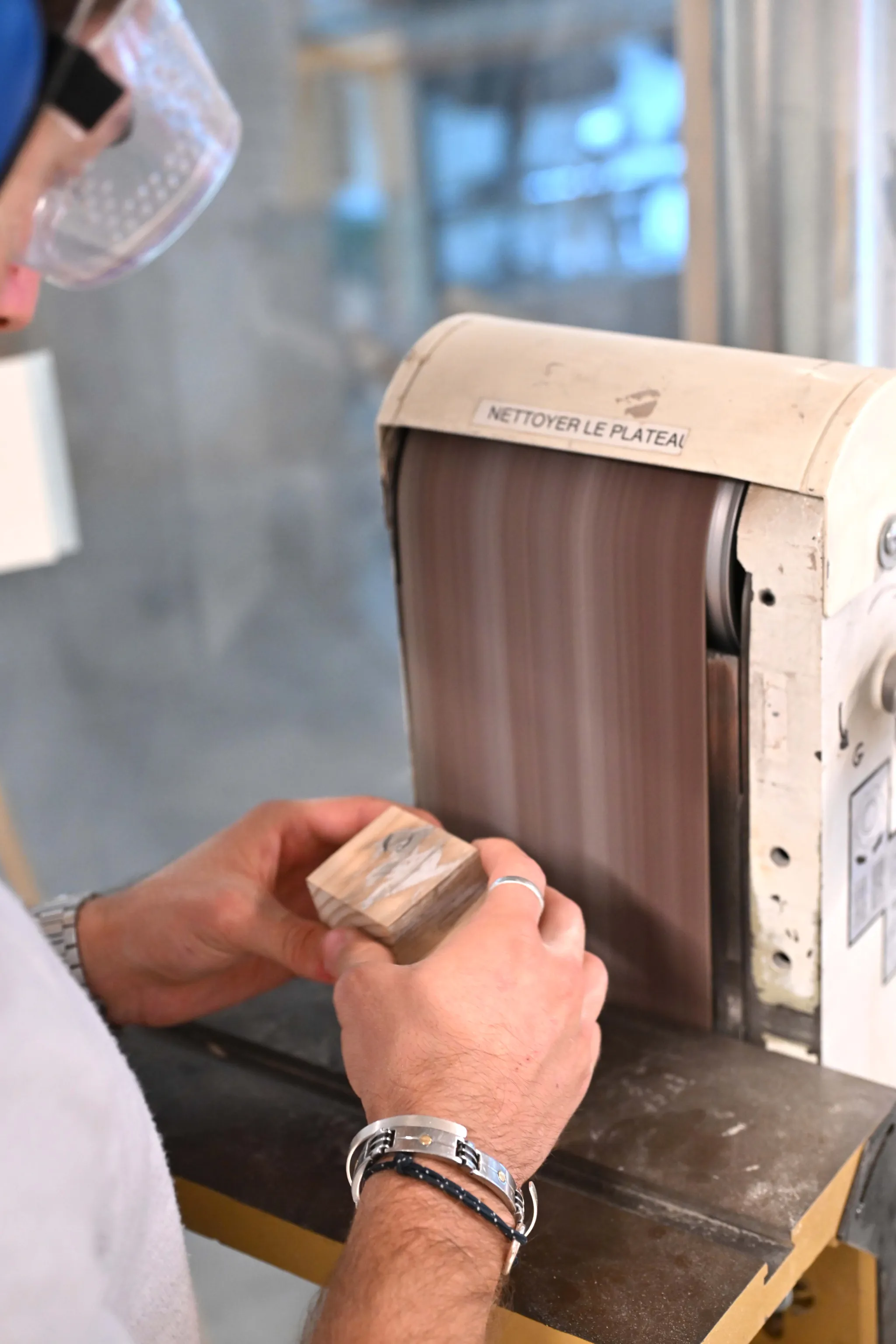 Etudiant travaillant sur une ponceuse à bande